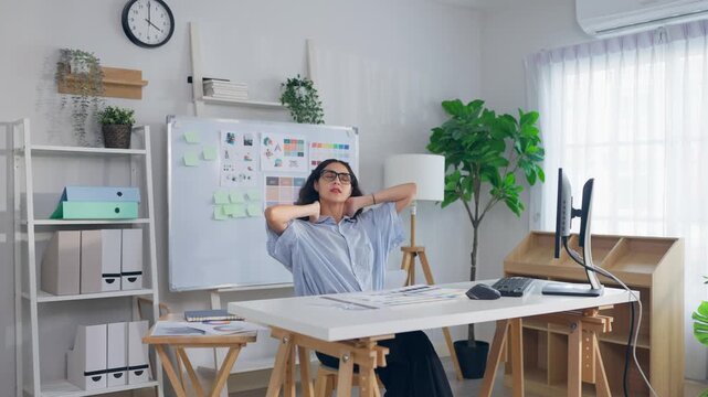 Young Hispanic woman designer stretching body while working in an office.