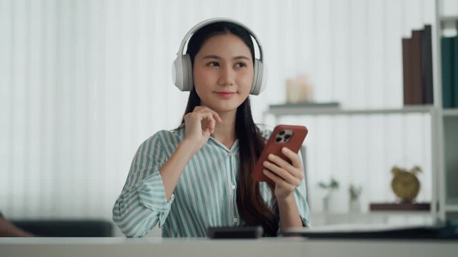 Woman enjoys music with headphones sitting comfortably at home indoors