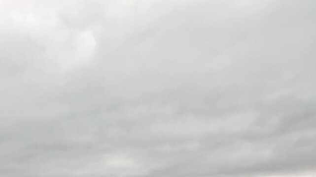 Bright overcast sky and soft gray clouds fill the entire frame. The surrounding view shows minimal framing, adding visual depth and surface detail to the composition.