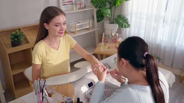 Female customer enjoying nail beauty treatment at modern nail salon.
