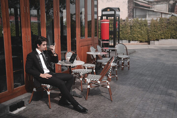 Obraz premium Man Relaxing Beside Bicycle At Outdoor Cafe On Urban Street.