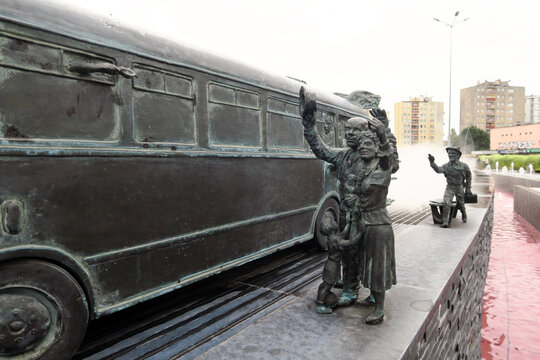 Kielce, Poland.  A sculpture by Sławomir Mick in front of the Kielce train station, featuring, among others, a Jelcz 43, commonly known as the "cucumber"