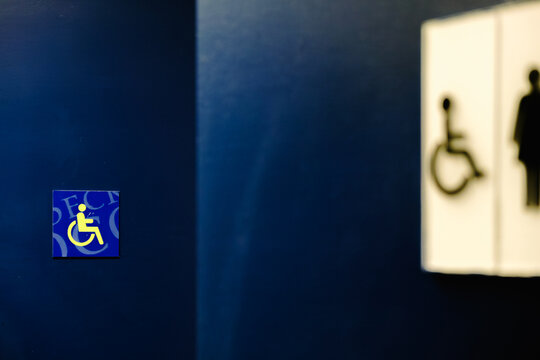 Sign for accessible restrooms on a blue wall