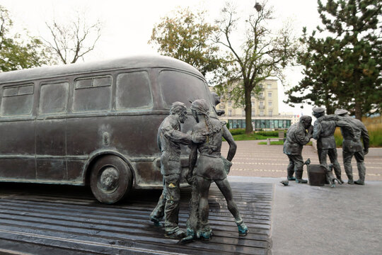Kielce, Poland.  A sculpture by Sławomir Mick in front of the Kielce train station, featuring, among others, a Jelcz 43, commonly known as the "cucumber"