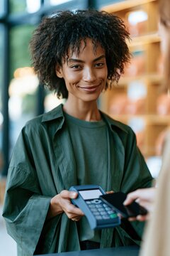 Woman presenting a card reader while a customer taps a phone for contactless payment for retail poster and online banner promoting modern checkout