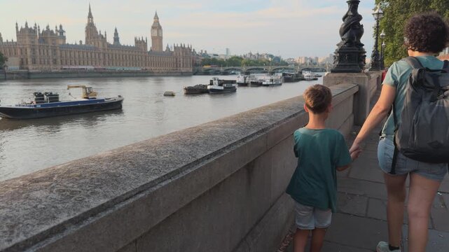 Mother and Young Son Walking Along the Thames Opposite the Houses of Parliament