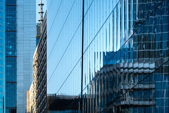 Reflective office facade in Wola, Warsaw, Poland, showing mirrored surfaces and neighboring business towers in the contemporary financial district.