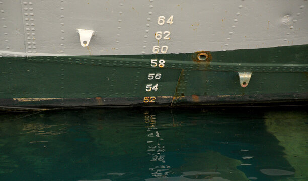 Draft marks on a ship hull at the waterline in the port of Rijeka, Croatia. Naval architecture displacement measurement detail.