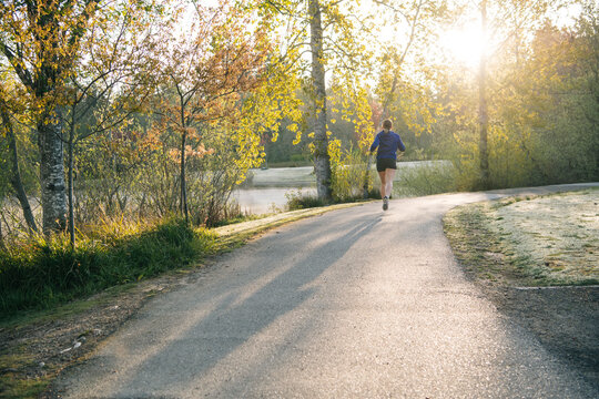 White runner jogging on park path