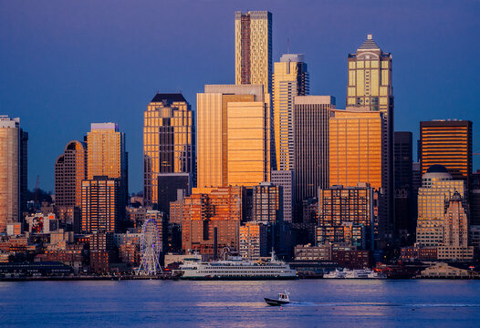 Seattle skyline at sunset with ferries and boats on waterfront
