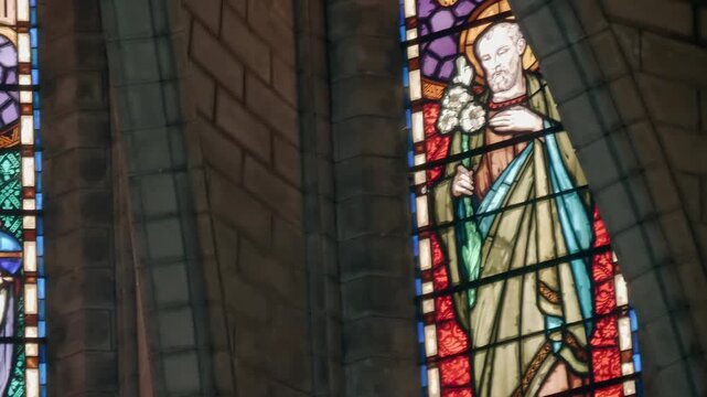 A stained glass window depicting a classic religious portrait of Jesus Christ holding a globus cruciger (an orb and cross) with a halo, wearing white and red robes, and holding an orb 