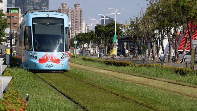 Kaohsiung, Taiwan - September 8, 2025: A Kaohsiung Light Rail train runs on a dedicated grassy track through the city in the Pier-2 Art Center