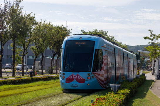 Kaohsiung, Taiwan - September 8, 2025: A Kaohsiung Light Rail train runs on a dedicated grassy track through the city in the Pier-2 Art Center