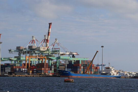 Kaohsiung, Taiwan - September 8, 2025: Container cranes and stacked shipping containers at a busy terminal in Kaohsiung Port.