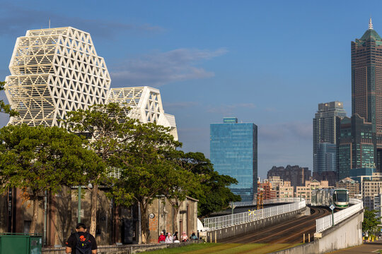 Kaohsiung, Taiwan - September 8, 2025: Kaohsiung Music Center's white geometric towers rise above a passing light rail tra