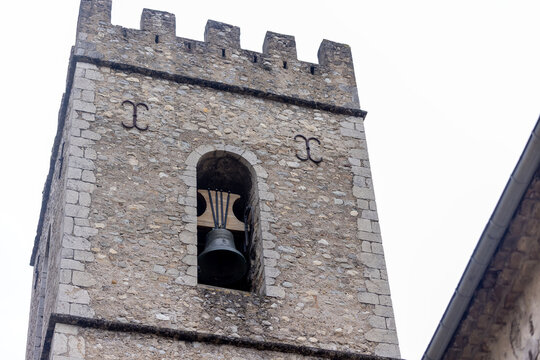 The crenellated bell tower of Entrevaux Cathedral features a bronze bell and defensive battlements.