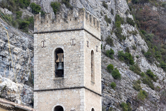 The crenellated bell tower of Entrevaux Cathedral features a bronze bell and defensive battlements.
