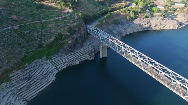 An Aerial View Captures Mourulle Bridge Spanning the Water in Xill&aacute;n, Chantada, Spain - Orbit Drone Shot