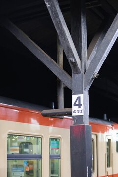 木造駅舎の古い柱とホームに停車する国鉄色の気動車