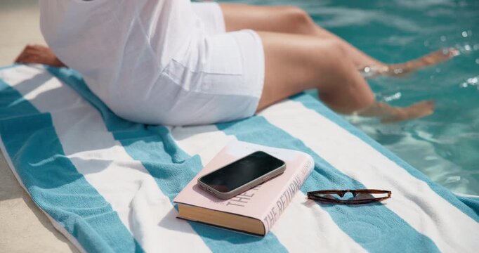 Person, hands and relax with drink in swimming pool for holiday vacation, summer break or getaway. Travel, accommodation and poolside with juice for luxury weekend or hospitality in spa or resort