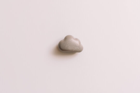 Single gray cloud-shaped magnet on a whiteboard with soft side shadow.