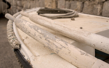 Vintage wooden oars and coiled rope on a small traditional boat in Rijeka, Croatia. Coastal maritime heritage detail. © YuliiaKettu