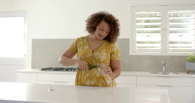 Lifestyle videos indoor of people doing activities at home, pouring beer into glass, woman standing