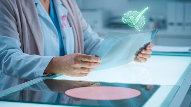 AI breast cancer detection and mammogram screening concept, female doctor with pink ribbon examining x-ray film on lightbox with AI brain checkmark for early diagnosis and women health