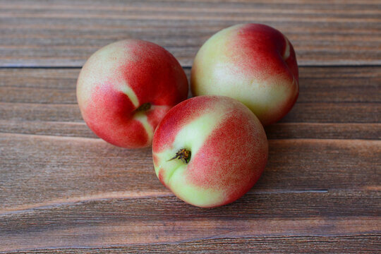 Three Fresh Nectarines on Wooden Surface, macro