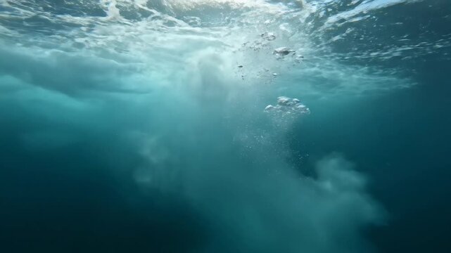 Underwater shot with moving water and bubbles while light shines through the surface