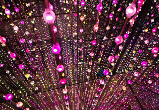 immersive space glowing geometric shapes, lights, and mirrors, geometric shapes floating nearby, abstract cosmic backdrop