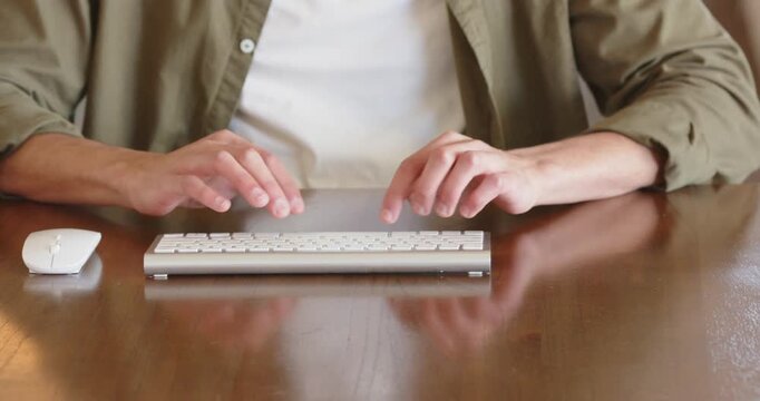 Typing on keyboard, man working from home with wireless mouse on desk