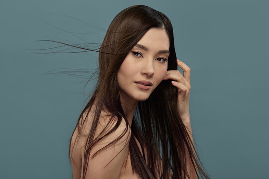 Beautiful female model with dark hair blowing in wind.
