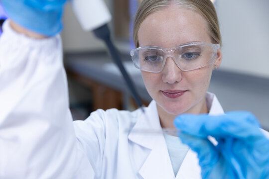 Biotechnology research concept. women scientist using micropipette to prepare sample beside microscope in laboratory. scientist, research, laboratory, pipette, science.