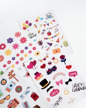 Colorful decorative sticker sheets with floral, birthday, and travel icons on a white background