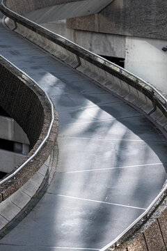 Curving elevated pedestrian ramp in Paris, France, showing sweeping concrete lines and contemporary urban infrastructure without people.