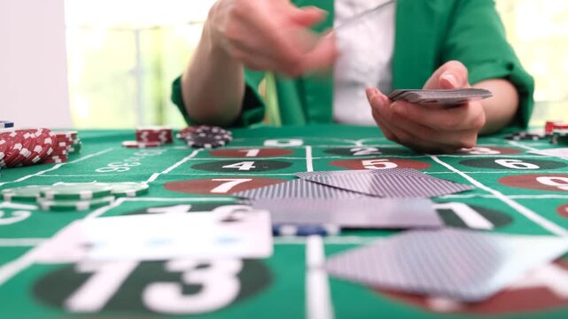 Woman croupier deals crisp playing cards to participants in casino. Neatly arranged betting chips and detailed roulette field time lapse
