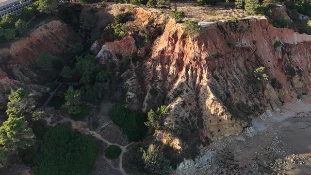 Falesia Beach, Algarve, Portugal. Golden mile beach with orange rocks, golden sand and turquoise sea. Aerial drone top view perspective. Famous travel destination in south of Portugal 