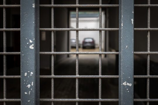 Parked Car Seen Through a Weathered Metal Security Gate