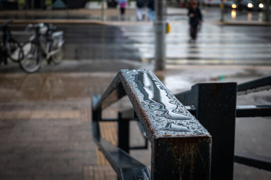 Rain Droplets Collect on a Weathered Metal Railing in the City