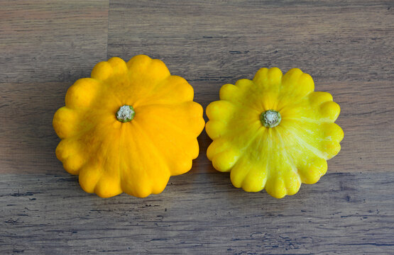 Two Yellow Pattypan Squash on Wooden Surface, flat lay