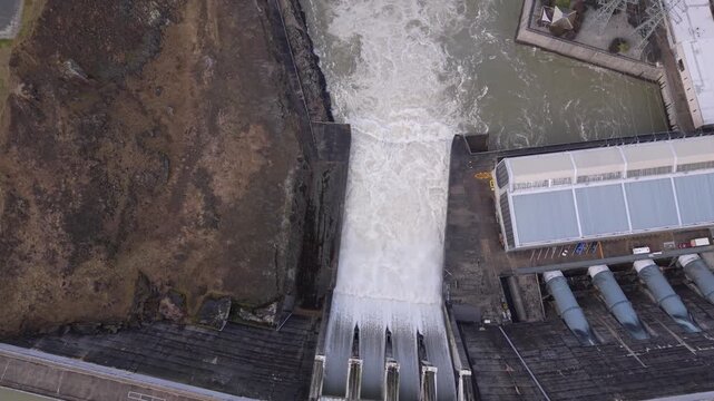 Aerial view rising from Clyde Dam spillway to reveal river and nearby Clyde township