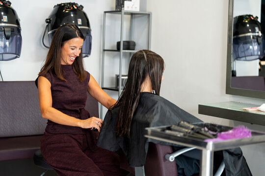 Hairdresser preparing client for haircut in beauty salon, focusing on wellness
