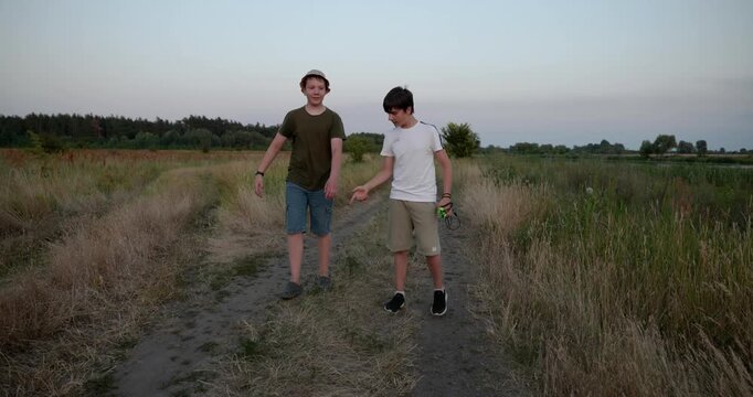 Two boys walk hiking on nature. Teenagers spending time together. 4K 10-bit