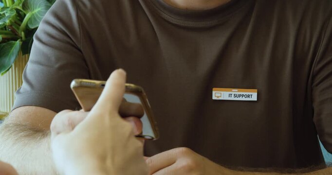 Close-up of IT support worker using a smartphone, representing technical assistance and digital customer service.