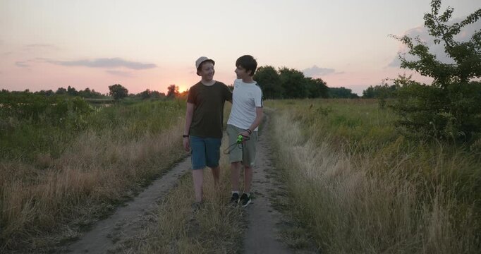 Two boys walk hiking on nature. Teenagers spending time together. 4K 10-bit