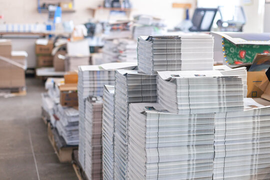 Stacks of printed booklets in professional printing house. Daily operations, industrial process of mass production, industry, manufacturing, results of printing services.
