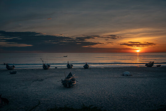 Sunrise over a beach with fishing boats