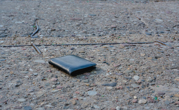 The lost wallet on the street, forgotten black leather object