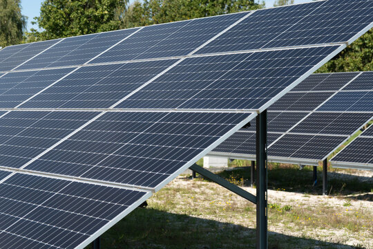 Ground mounted solar panels produce clean electricity on a local farm. Photovoltaic cells convert bright sunlight into sustainable power. Eco outdoor system lowers business utility costs.